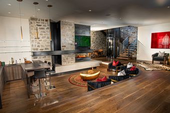 White Pine Canyon's spacious living room, showcasing the fireplace, a large dining table, and a glass elevator.