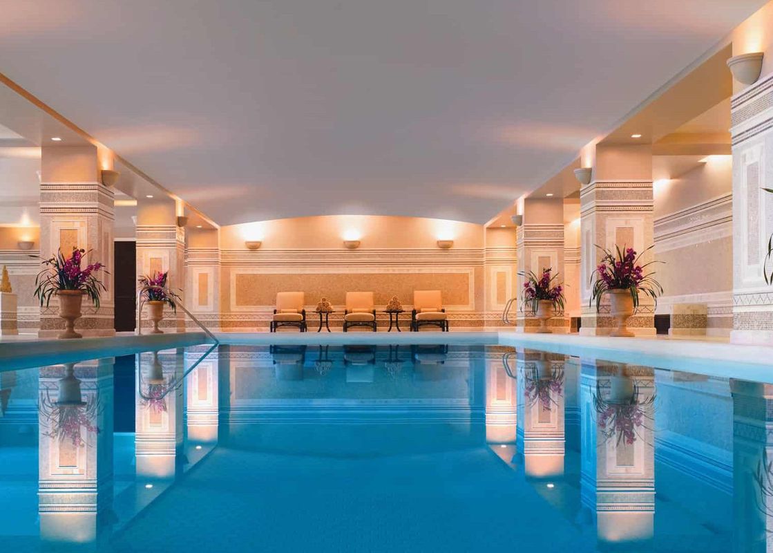 The Montage Three Bedroom Suite Resort View features an expansive indoor swimming pool with elegant columns and ornate wall details.