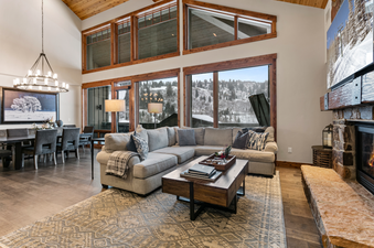 The living room of Black Diamond Lodge Four Bedroom Deluxe 241 with a large sectional sofa, a coffee table, and a fireplace in the background.