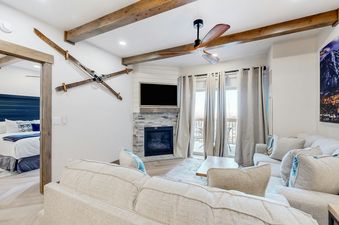A living room in Westgate 4607AB, featuring a fireplace, a large flat-screen TV, and two sofas with pillows.