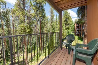 A private balcony at Beaver Village 514 provides a stunning view of the surrounding evergreen forest.