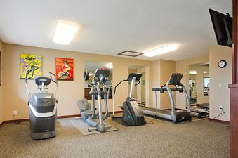 The fitness center at Ranch at Steamboat RA224 is equipped with an elliptical, treadmill, and stationary bike, complemented by vibrant artwork and natural light.