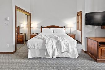 The Blackcomb Springs Studio features a comfortable bed, two nightstands with lamps, a television, and a spacious closet.
