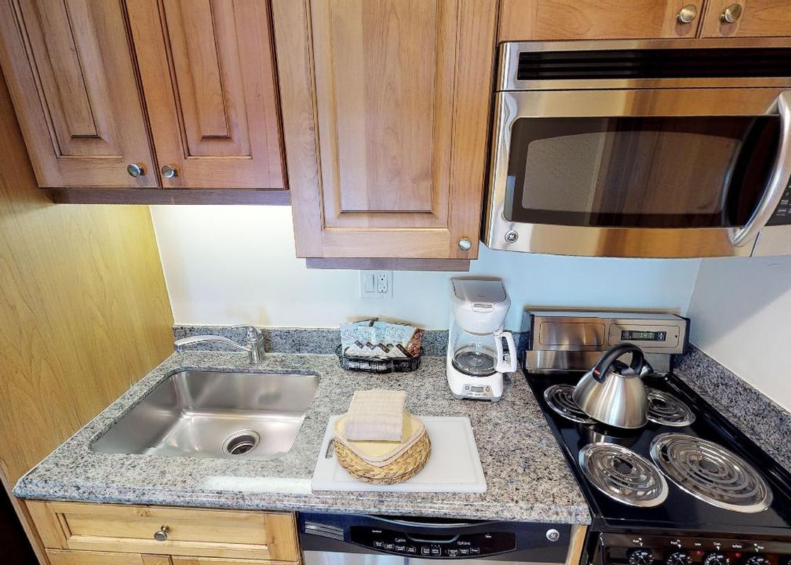 The kitchen in Manor Vail 283 has stainless steel appliances, granite countertops, and a coffee maker.
