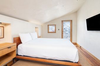 The bedroom in Peaks Penthouse 851 features a comfortable king bed with a white duvet.