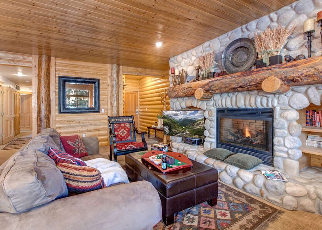 The living room in Black Bear 231 features a stunning stone fireplace and comfortable seating.