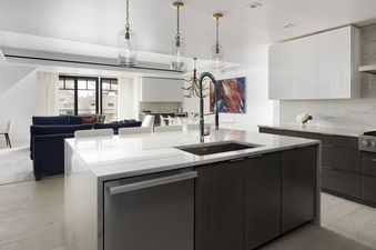 The kitchen in Northwoods Three Bedroom Residence features modern appliances, sleek cabinetry, and a large island with a breakfast bar.