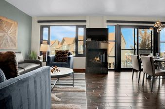 A spacious living area at Lowell 304 features comfortable seating, a modern fireplace, and large windows with scenic views, creating a welcoming and elegant atmosphere.