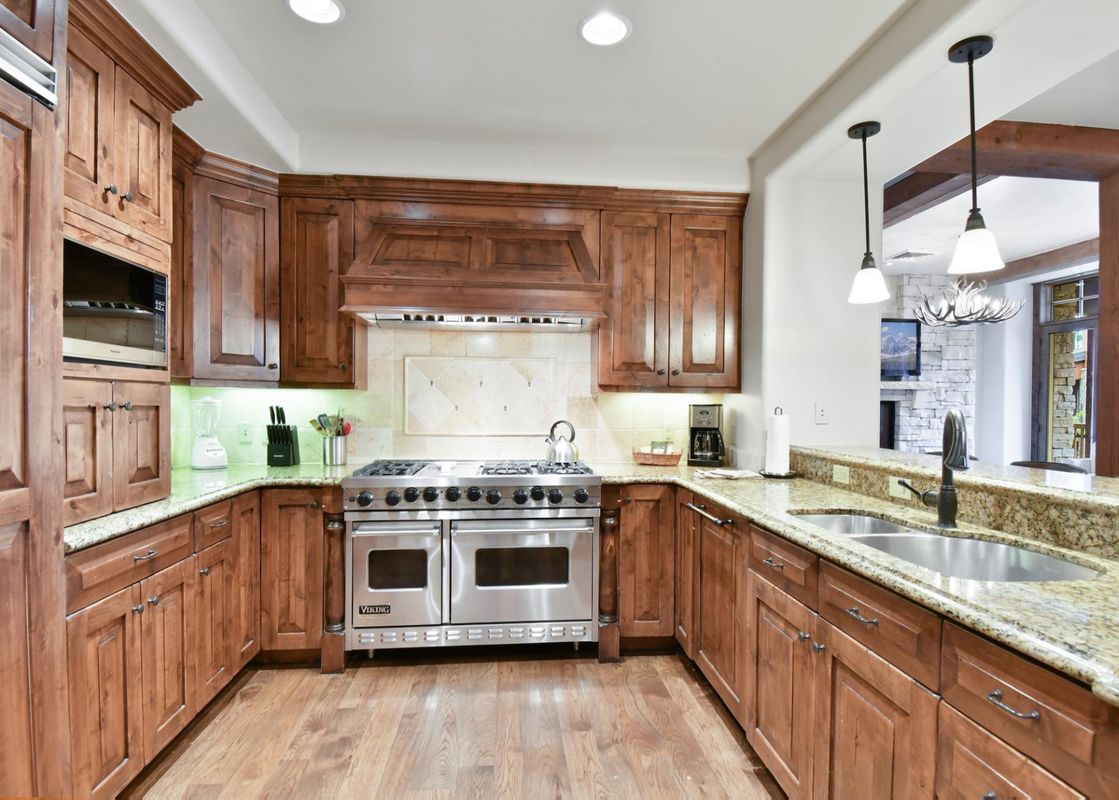 The fully equipped kitchen in Silver Strike Lodge 304 features rich wooden cabinetry, granite countertops, and modern stainless steel appliances.