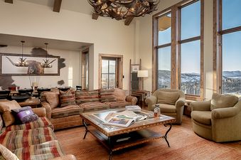 The living room in Edgemont 2803 Nightfall Ridge showcases elegant furnishings and beautiful views.