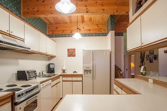 A well-equipped kitchen with white appliances and wooden accents, featuring a refrigerator, stove, and microwave.