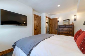 Bedroom at Wild Cat Lair with comfortable bed and wooden dresser.