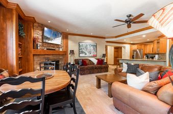 A living room with a fireplace, a dining room table, and a couch.