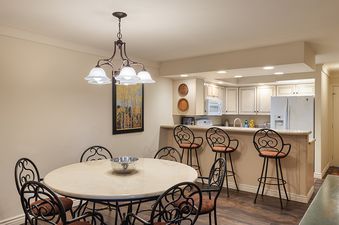 Dining area with a table and chairs near an open kitchen in Enzian 217.