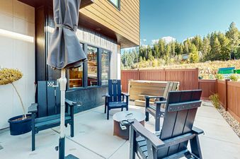 Sandlewood Sanctuary's backyard features a hot tub, a fire pit, and a patio furniture set.