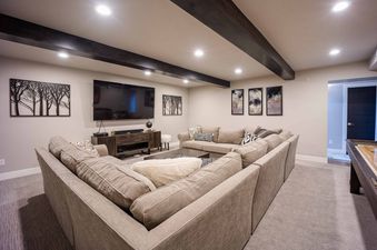 The spacious living room in Frostwood Villa 4302 features comfortable seating, a large flat-screen television, and a cozy fireplace. The room is perfect for relaxing after a day of skiing or hiking.