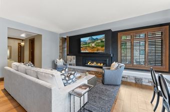 A living room with a fireplace, a large TV, and a comfortable couch.