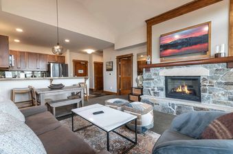 A modern living room with a fireplace, a couch, and a coffee table.
