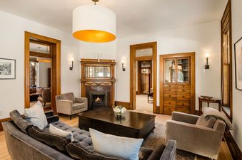 A luxurious living room at The Sardy House featuring a fireplace, plush seating, and rich wooden accents.