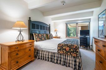 A bedroom with a king size bed, nightstands, and a dresser.