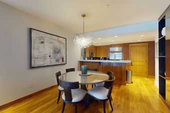 A dining room table with chairs is situated in the center of the image.