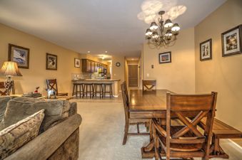 A living room with a couch and a dining table set with chairs
