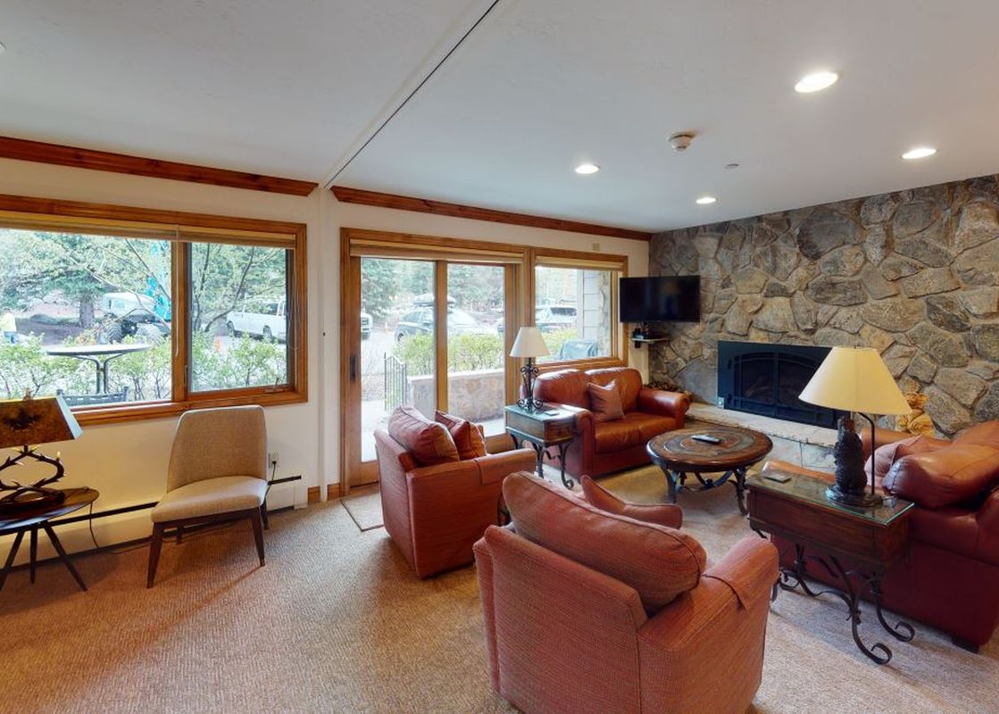 Manor Vail 139 living room with fireplace, TV, and comfortable leather furniture.