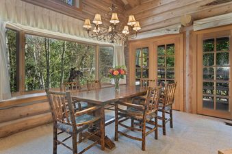 Dining room in Pine Inn 3 featuring a large wooden table with six chairs and a chandelier above it.