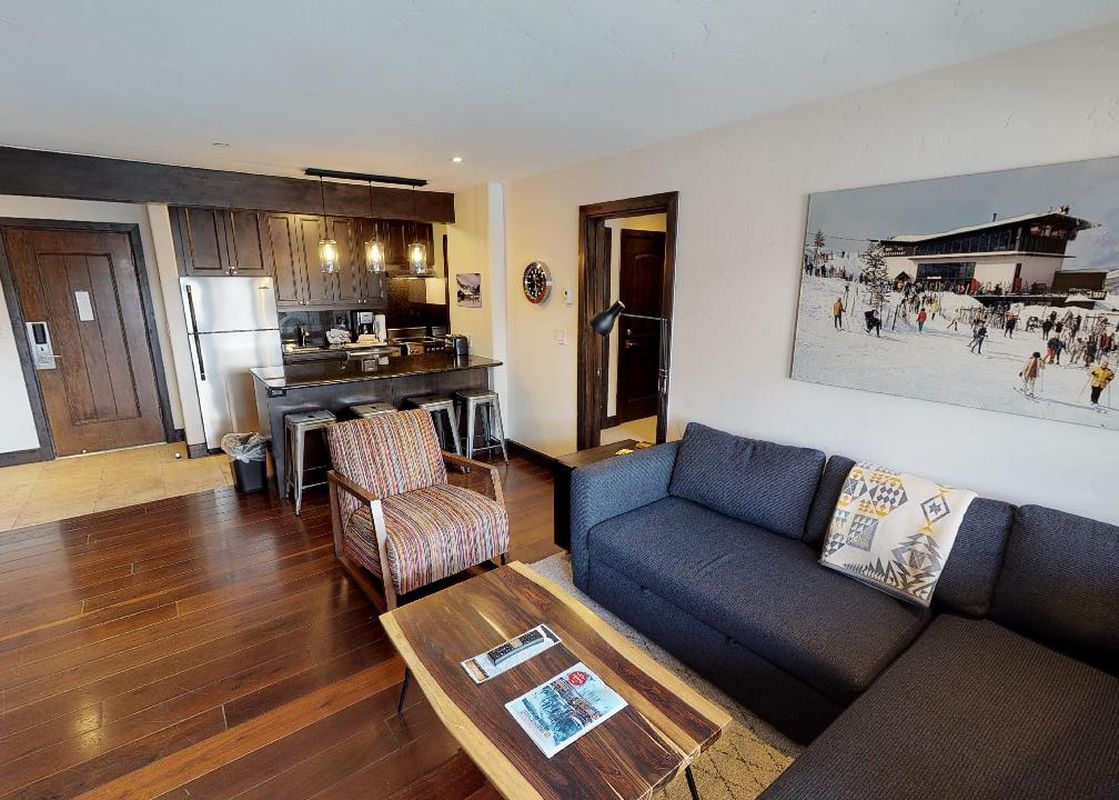 The living room of Manor Vail 284, with a large couch, coffee table, and a view of the kitchen.