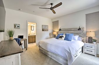 A modern and rustic bedroom at the Rendezvous Retreat features a comfortable bed, a dedicated workspace, and an en-suite bathroom.