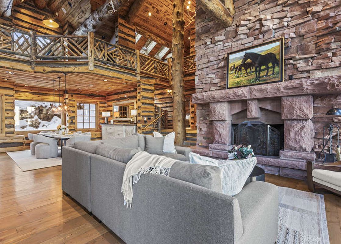 The Treehouse in Canyons Village features a large sectional couch, a stone fireplace and a spacious open floor plan.
