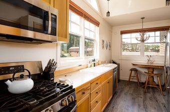The kitchen in Moonlight Basin Saddle Ridge B5 features stainless steel appliances, wood cabinets, and a view of the mountains.