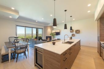 A modern open-concept kitchen and living area with mountain views from Juniper 801.