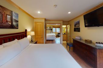A hotel bedroom with a king bed and a flat screen TV.