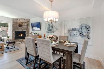 Dining room at Abode at Kings Gold with set table and stone fireplace.