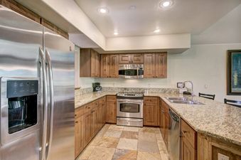 A fully equipped kitchen with wooden cabinetry and stainless steel appliances at Mountain Thunder 2 Bedroom TH.