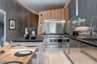 Sleek contemporary kitchen at The Pinnacle at Powder Ridge with stainless steel finishes and wood-paneled walls.