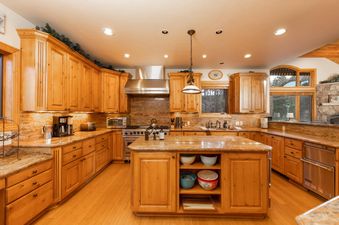 The kitchen at Fireside Lodge features light wood cabinetry, granite countertops, and modern stainless steel appliances.