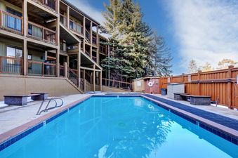Outdoor swimming pool at Snowcrest 207 next to the lodge under a blue sky.