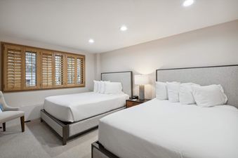 Two queen beds in a well lit room.