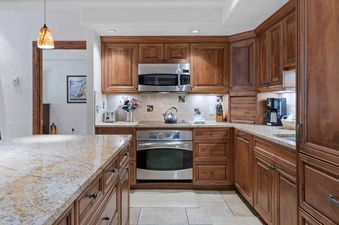 A modern kitchen with stainless steel appliances and wood cabinets.