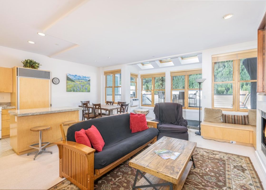 Living area in Willow 302 featuring a wood frame futon sofa, a wooden coffee table and a fireplace.