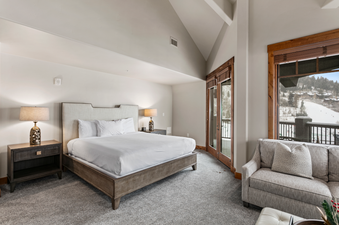 The master bedroom of Black Diamond Lodge Four Bedroom Deluxe 241 features a large king bed and a private balcony with stunning mountain views.