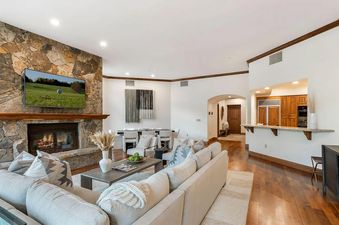 The living room of Centennial Vista features a large sectional sofa, a fireplace, and a flat-screen TV.