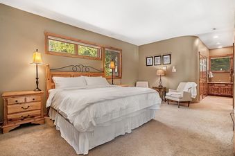 A spacious and inviting bedroom with a king bed, warm wood accents, and cozy seating area in Trademark Views.
