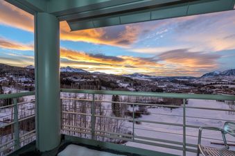 The view from the balcony at Penthouse At The Peaks 746 features the surrounding mountains and a stunning sunset.