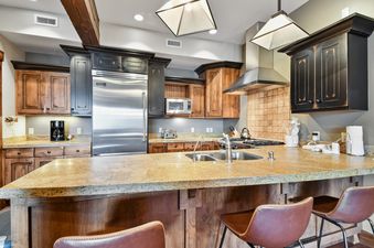 A kitchen with wood cabinets, stainless steel appliances, and a granite countertop.