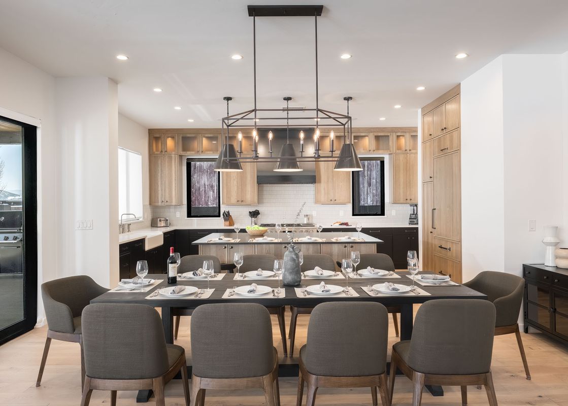 The dining area is furnished with a large dining table and modern chairs.