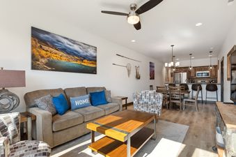 A wide view of the open concept living room, dining area, and kitchen of Columbia Crest 301, showcasing stylish decor and comfortable furnishings.