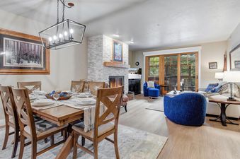 Dining table and living room setup in Town Pointe A102 with a fireplace.